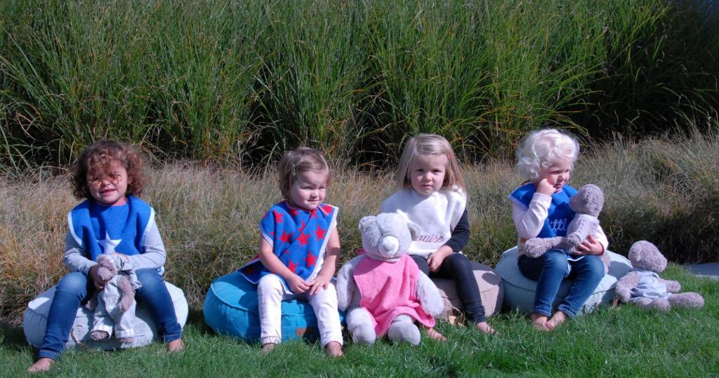 4 Children sitting on fabrics by Clatysse